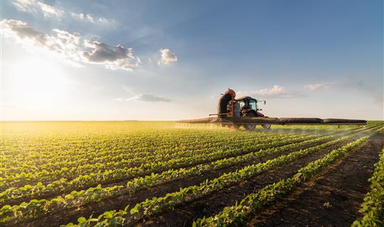 Tractor treating crops in field