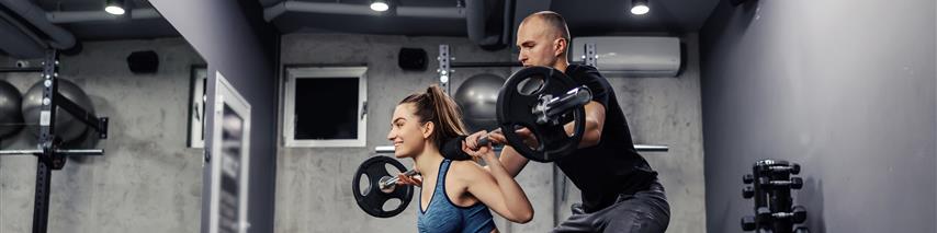 Personal Trainer Helping Woman With Weights