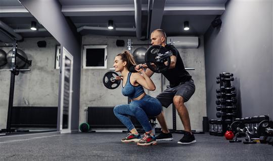 Personal Trainer Helping Woman With Weights